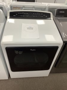 Front-loading washing machine with control panel on top; paper sign shows SALE PRICE $325.00