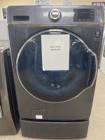 Front-loading Samsung washer with a sale price sign reading $550.00 taped to the door.
