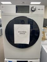 Stacked front-loading washer and dryer in a showroom, with a sale price sign of $495 on the door.