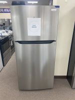 Stainless steel Frigidaire refrigerator with a 'NEW $550.00' sign taped to its front in a showroom.