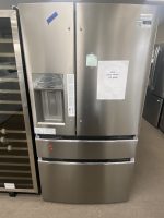 Stainless steel French-door fridge with water dispenser on the left, sale flyer taped to the right door showing $1,800.