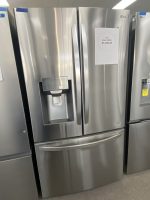 Stainless steel LG French-door refrigerator on display with a sale price card reading $1,300.00 attached to the door
