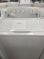 White front-loading washing machine with control panel; paper shows sale price $295.00 on top of the drum area.