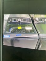 60157127-177e-42e2-a72d-60852c7830d9-18219-0000064e2da09885_file - Discount Appliances Close-up of a grey control panel with a large central round dial, small screens, and a numeric keypad on a machine surface.