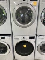 619694e2-6b5f-4717-a700-b94e70328d83-29393-00000336dae7c70c_file - Discount Appliances Stacked front-loading washing machines in a showroom display, with a large circular door and a yellow sticky note on the top unit's front panel.