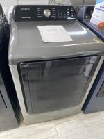 b2ffb5d3-0b0a-4f6e-851e-bc851f2f3184-17531-000005f8db3296bd_file - Discount Appliances Front view of a Samsung top-load washing machine with a sale price sheet on its lid.