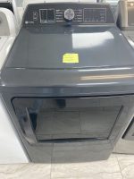 ff76b7fe-6f83-41f3-a5ae-f497c8081b7d-18219-0000064e49e244a0_file - Discount Appliances Front-loading GE Profile washer with a large central dial on the control panel; the top has various cycle options and a yellow sticky note on the lid. The front door is open, revealing a dark drum interior.